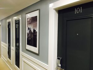 black hotel room doors and corridors painted grey with pictures of the grand national on the walls