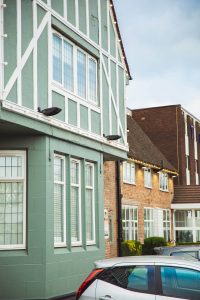 outside picture of The Park HOtel in liverpool, with tudor style outside beams and painted green and natural brick